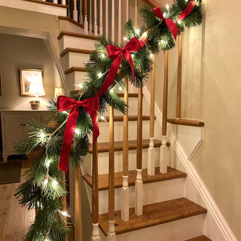 a wooden staircase banister wrapped with evergreen garland and red ribbon, white string lights woven through, warm home interior, no text, no words, no letters, no signs, no watermarks a wooden staircase banister wrapped with evergreen garland and red ribbon, white string lights woven through, warm home interior, no text, no words, no letters, no signs, no watermarks